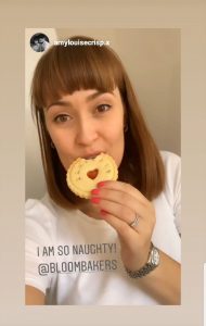 Amy Louise bites into personalised biscuit made by BLoom Bakers