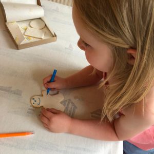 Girl decorates a thank you teacher biscuit